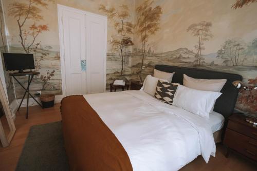 a bedroom with a large bed with white sheets and pillows at House Sao Bento in Lisbon