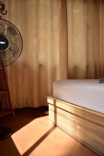 a bedroom with a bed and a fan at Hiti fusa in Pātan