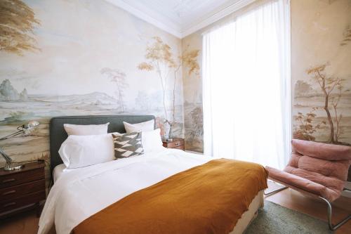 a bedroom with a bed and a painting on the wall at House Sao Bento in Lisbon