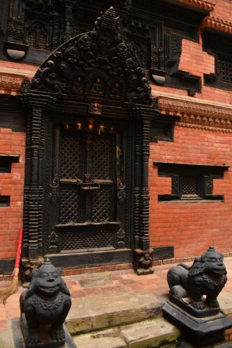 two statues of lions in front of a building at Hiti fusa in Pātan