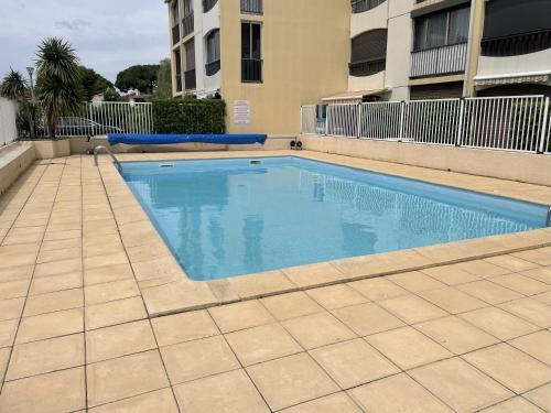 a swimming pool in a courtyard with a building at Studio Argelès sur Mer in Argelès-sur-Mer