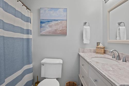 um banheiro com um vaso sanitário, uma pia e um espelho em 818 Treeloft Cottage em Seabrook Island