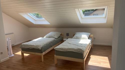 two beds in a room with two windows at Ferienhaus mit Terrasse und Garten in Lippstadt