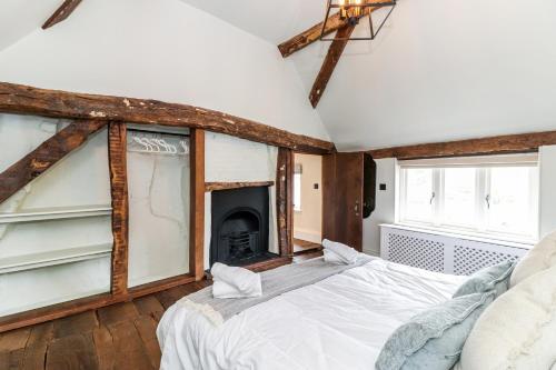 a bedroom with a bed and a fireplace at Tuffs Farm Cottage in Kings Langley