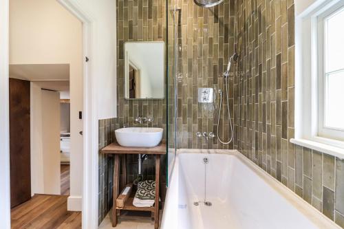 a bathroom with a tub and a sink at Tuffs Farm Cottage in Kings Langley