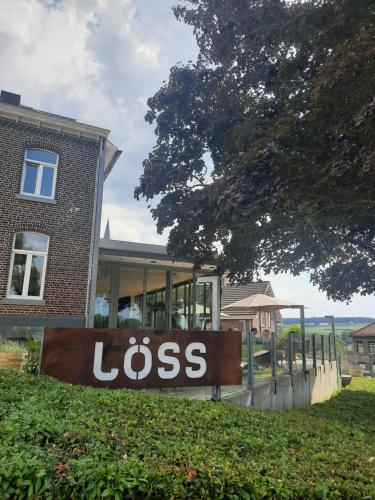 a sign in the grass in front of a house at LÖSS Wijnhotel en Smaaklokaal in Vijlen