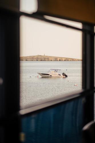 Un barco en el agua a través de una ventana. en Gillieru Harbour Hotel, en St Paul's Bay
