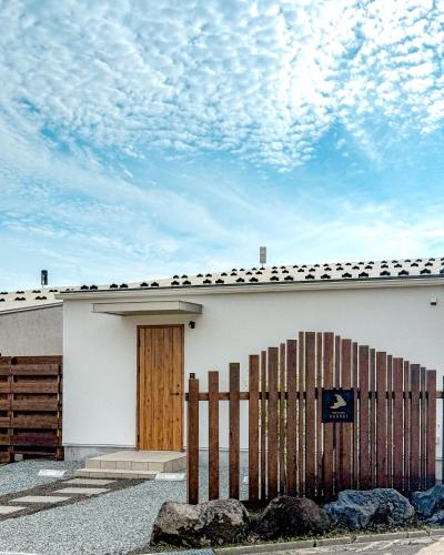a white building with a wooden door and a fence at - YURAGI - TSUKI me CHILL in Oiwake