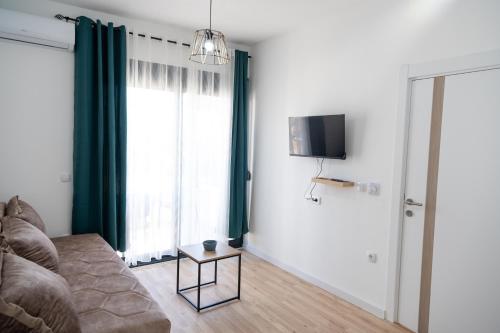 a living room with a couch and a tv at Odore di mare in Ulcinj