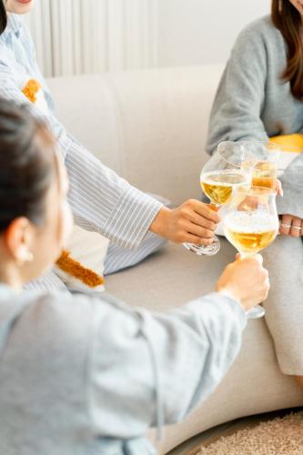 a woman holding two glasses of white wine at - YURAGI - TSUKI me CHILL in Oiwake