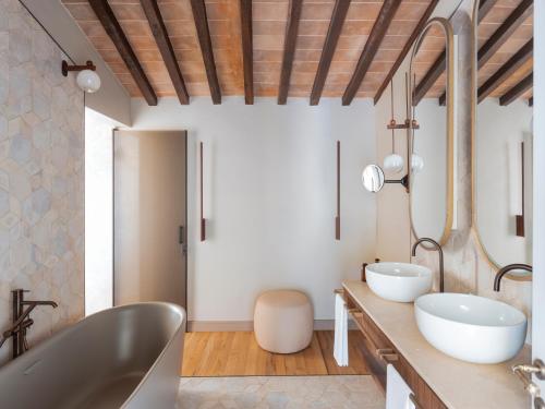 a bathroom with two sinks and a tub at Borgo Dei Conti Resort Relais & Chateaux in Monte Petriolo