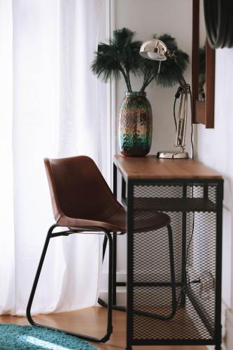 a desk with a chair and a vase with a plant at House Sao Bento in Lisbon