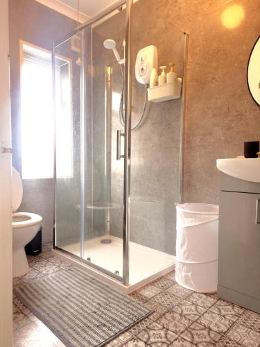a shower with a glass door in a bathroom at Cosy 3 bed house in Doncaster in Kirk Sandall