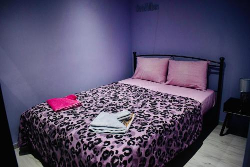 a purple bedroom with a bed with two towels on it at SkiathitissasMaison in Skiathos