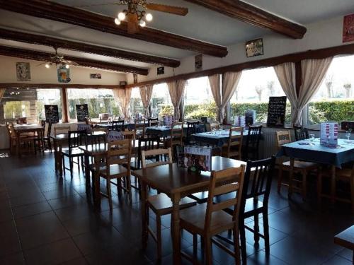 une salle à manger avec des tables et des chaises dans un restaurant dans l'établissement Les Charmilles 1, à Ardres