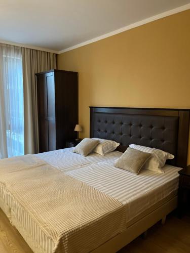 a bedroom with a large bed with white sheets and pillows at SoloApartment in Sunny Beach