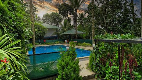 a swimming pool in the middle of a garden at Green Aura By BOB in Sultan Bathery