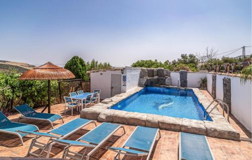 - une piscine avec des chaises et un parasol sur la terrasse dans l'établissement Nice Home In Villanueva De La Concepcion, à Villanueva de la Concepción