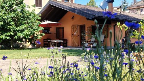 Una casa con flores moradas en el frente. en Residence Lago Blù -Riccio, en Pergine Valsugana