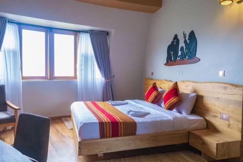 a bedroom with a bed with a wooden head board at Ndere Echifuuha Resort in Kisoro