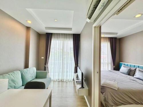a hotel room with a bed and a couch and a room at Blu X Bangsaen97 in Bangsaen