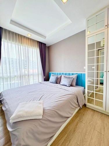 a large bed in a room with a large window at Blu X Bangsaen97 in Bangsaen