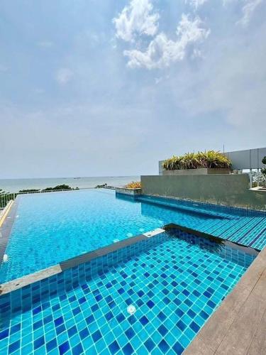a large blue swimming pool next to the ocean at Blu X Bangsaen97 in Bangsaen