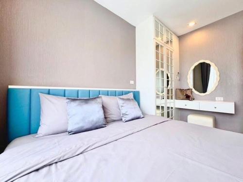 a bedroom with a large bed with a blue headboard at Blu X Bangsaen97 in Bangsaen