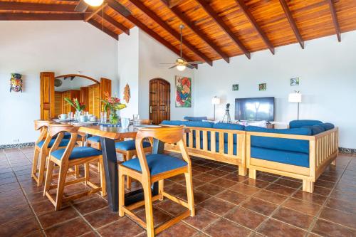 a living room with a dining table and a couch at Privacy-waterfall-pool-sleeps 8-near Beach in Matapalo