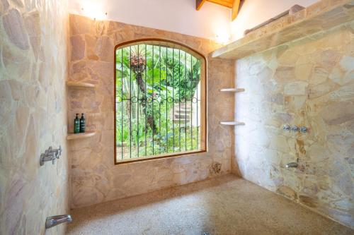 a bathroom with a window and a walk in shower at Privacy-waterfall-pool-sleeps 8-near Beach in Matapalo
