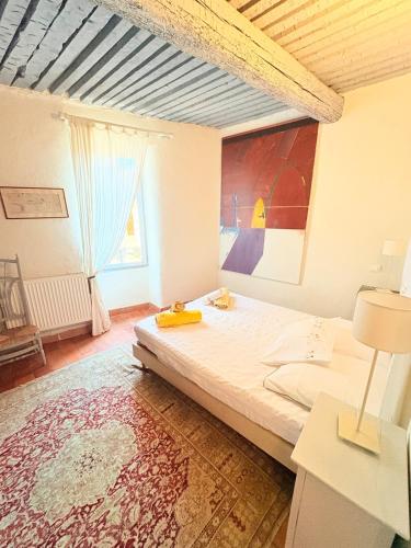 ein Schlafzimmer mit einem Bett und einem großen Fenster in der Unterkunft Les jardins de Montbazin in Montbazin