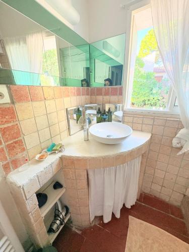 ein Badezimmer mit Waschbecken und großem Spiegel in der Unterkunft Les jardins de Montbazin in Montbazin