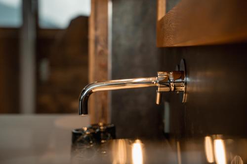 a chrome water faucet sticking out of a sink at Panoramahotel Watles in Malles Venosta
