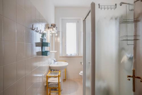 a white bathroom with a sink and a toilet at L'Elicriso in Castiglione della Pescaia