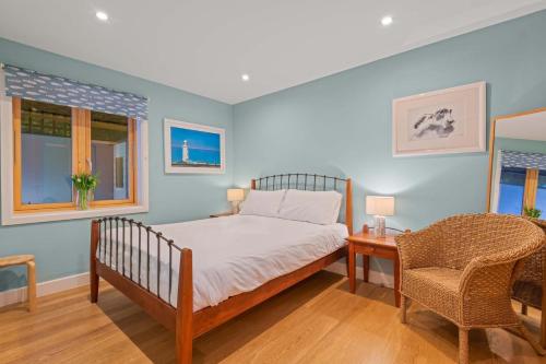 a bedroom with a bed and a table and a chair at House 36 in Looe