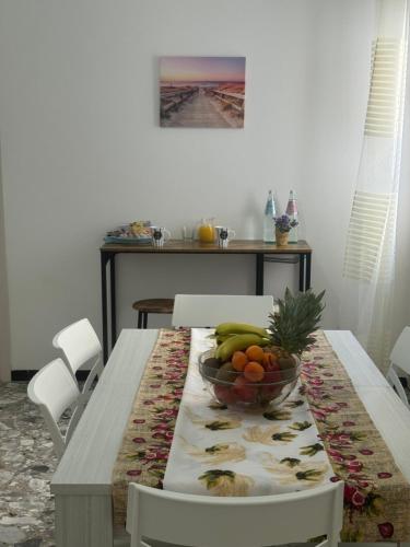 a dining room table with a bowl of fruit on it at Blanche Apartments in Porto Torres