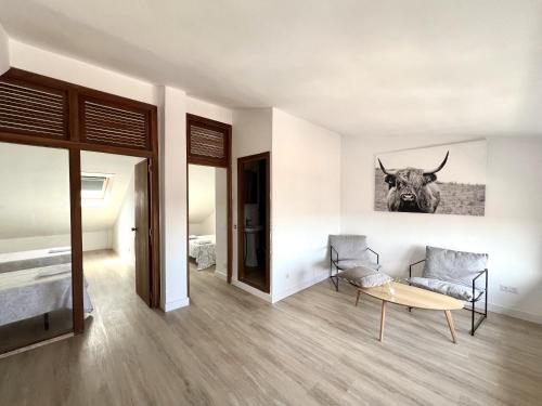 a bedroom with a table and a cow picture on the wall at BaruHaus duplex piscina y parking Villamañán 2 in Villamañán