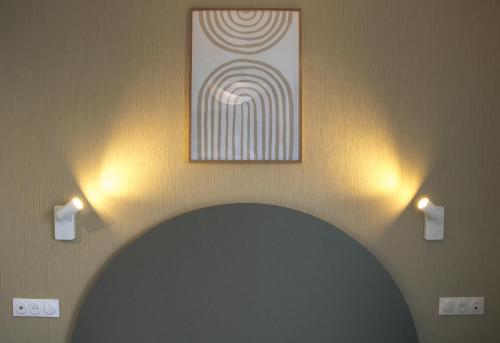 a room with a painting on the wall and two lights at Résidence Bordeaux Sud Pessac in Pessac