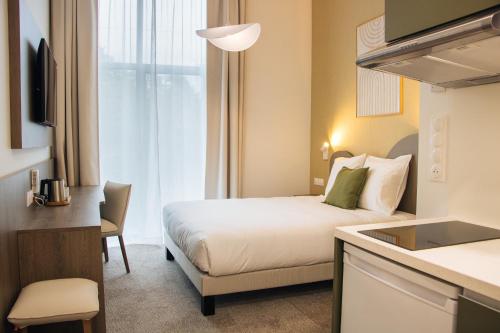 a hotel room with a bed and a kitchen at Résidence Bordeaux Sud Pessac in Pessac