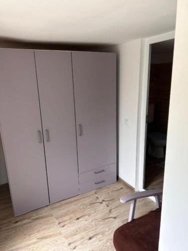 a room with white cabinets and a chair at Yellow House in Eforie Nord