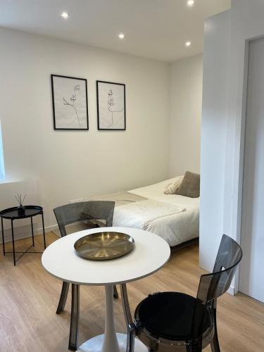 a room with a bed and a table and chairs at Le petit Yvours, Irigny in Irigny