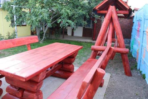 a wooden table and bench with a wooden ladder at Yellow House in Eforie Nord