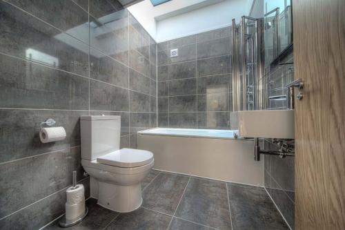 a bathroom with a toilet and a bath tub at House 6 in Looe