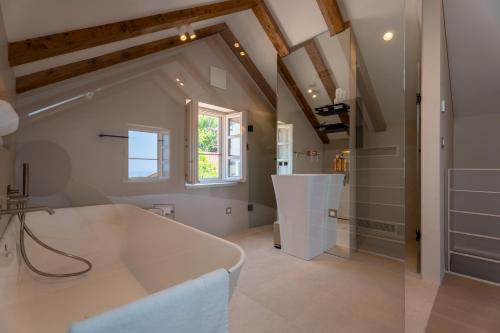 a bathroom with a white tub and a window at Maxima Comoda luxury villa in Dubrovnik