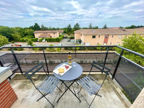 - une table et des chaises sur un balcon avec une bouteille de vin dans l'établissement 