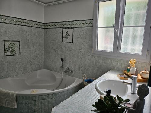 La salle de bains est pourvue d'une baignoire et d'un lavabo. dans l'établissement les lauriers roses, à Saint-Raphaël