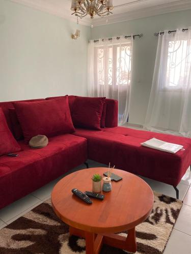 a red couch in a living room with a table at Appartements Meublés Odza Yaoundé by DITEX in Yaoundé