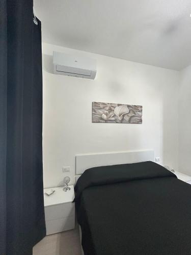 a bedroom with a black bed and a white wall at Villa Alena in Montallegro