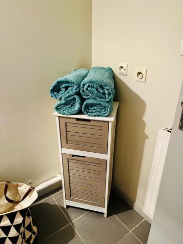 - une pile de serviettes sur une table dans la salle de bains dans l'établissement Appartement agréable spacieux, à Clermont-Ferrand