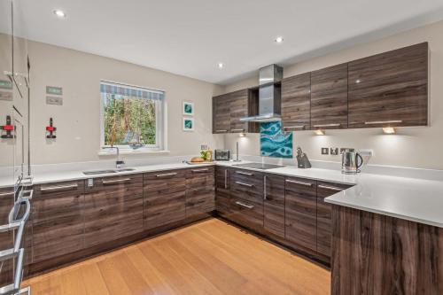 ルーにあるHouse 7の木製のキャビネットと窓のある広いキッチン